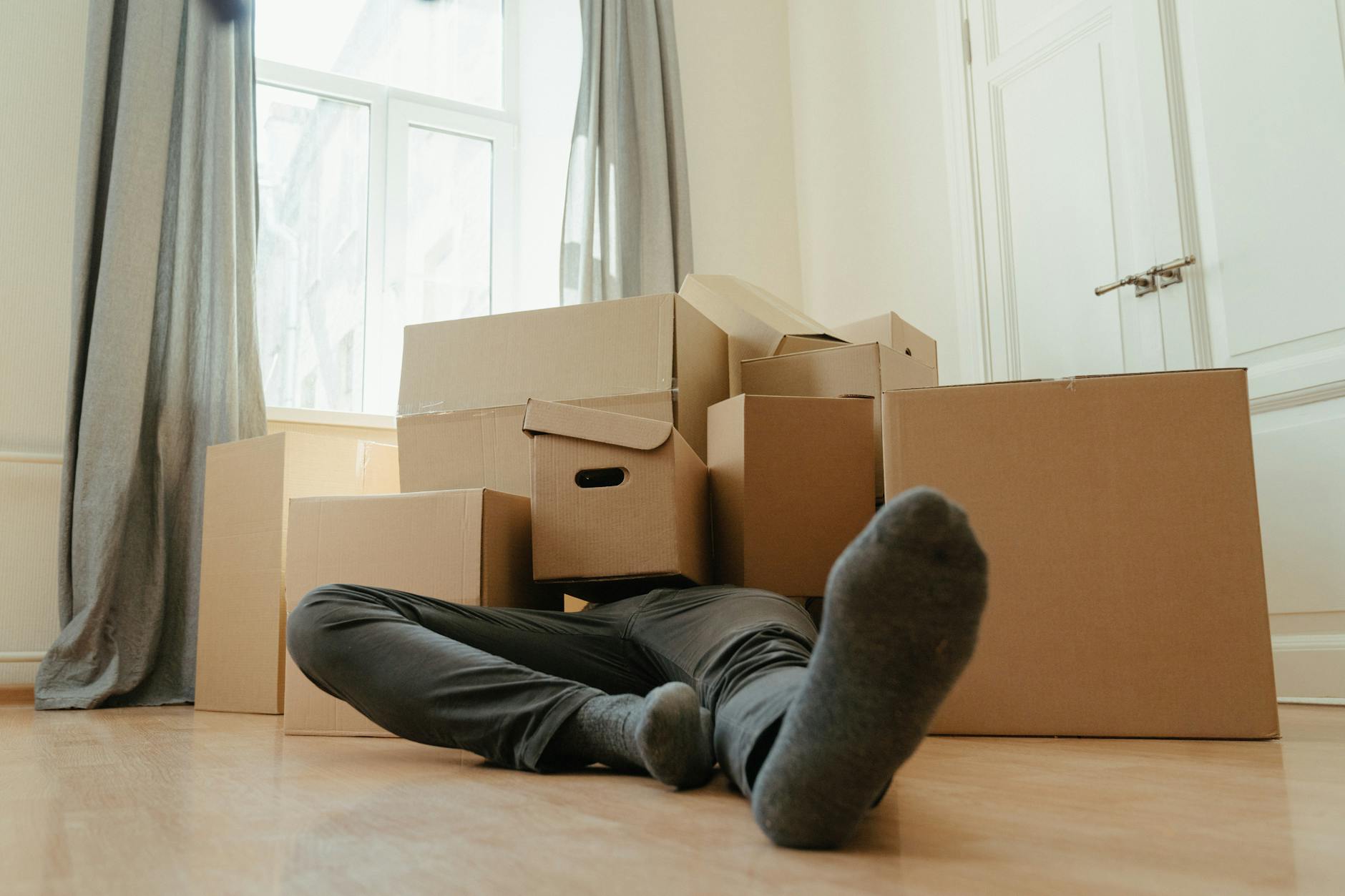 person in black pants sitting on brown cardboard box