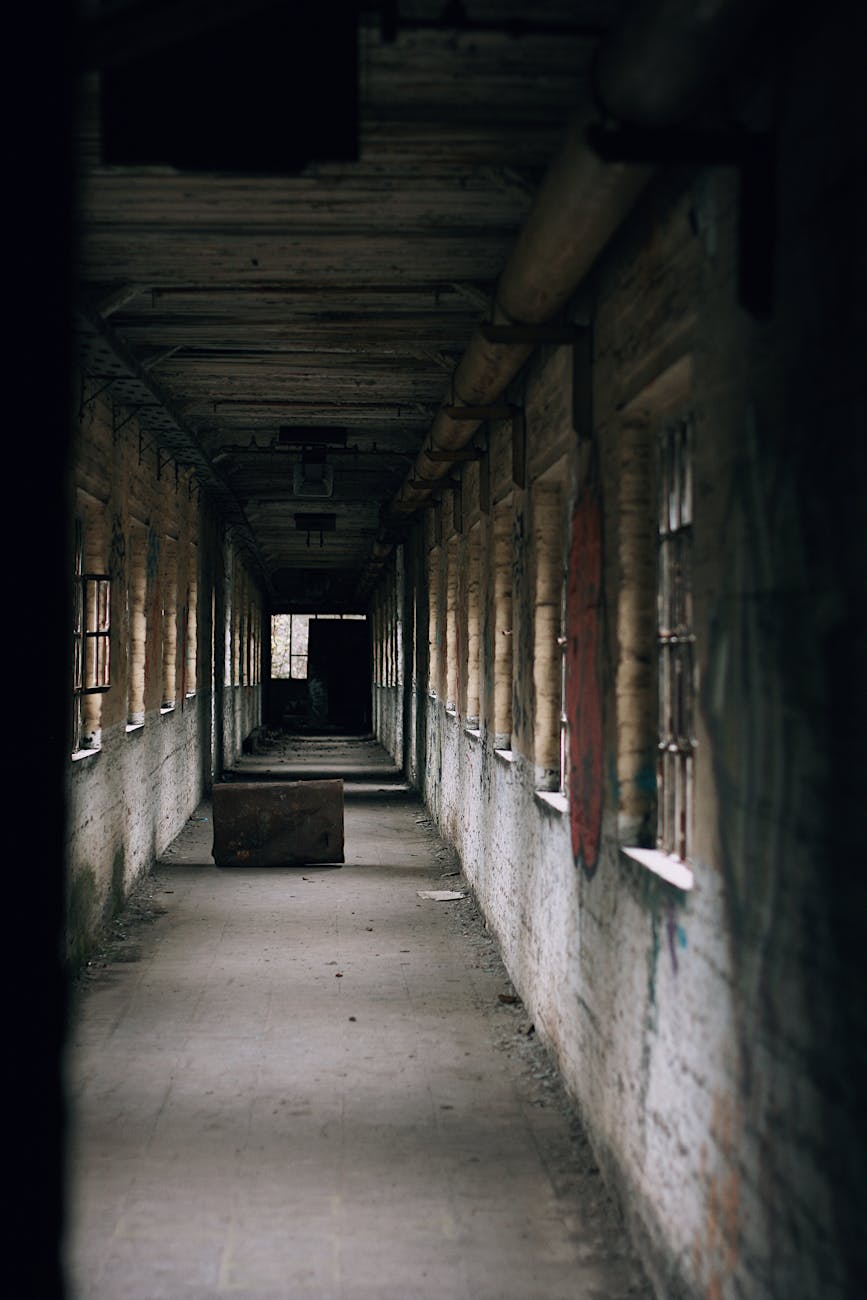 eerie abandoned building corridor with dramatic shadows